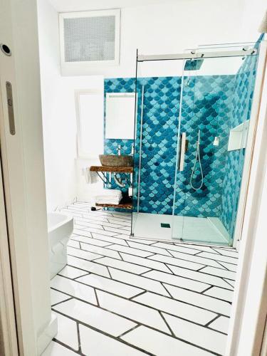 a bathroom with a shower with blue and white tiles at B&B Historia in Pozzuoli
