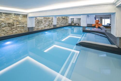 a large swimming pool with a teddy bear in the middle at Hotel La Chaudanne in Méribel