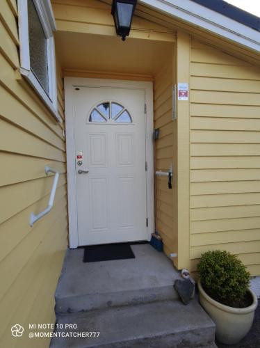 a white door on the side of a house at Guest room in private house in Ålesund