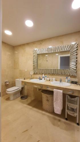 a bathroom with a sink and a toilet and a mirror at Magnolia Luxury Apartment by AltamarHomes in Adeje