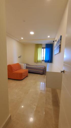 a living room with an orange couch in a room at Magnolia Luxury Apartment by AltamarHomes in Adeje