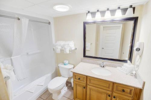 a bathroom with a toilet and a sink and a mirror at Oceanfront 3BR/2BA, Ocean Reef, Waterpark in Myrtle Beach