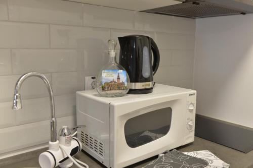 a bottle of wine sitting on top of a microwave at Apartman Liliom in Subotica