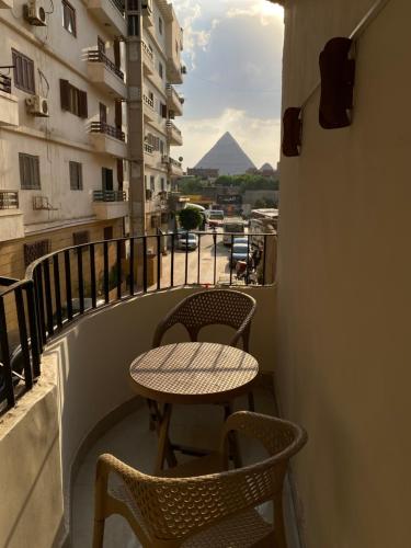 Asma Pyramids View في القاهرة: طاولة وكراسي على شرفة مطلة على هرم