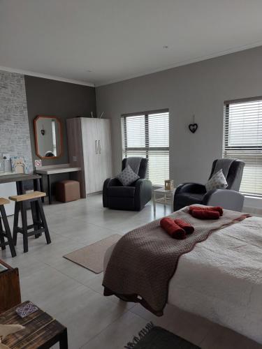 a bedroom with a bed and a living room at Silver Oaks Airbnb in Langebaan