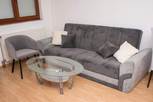 a living room with a couch and a glass table at Apartman Vesna in Doboj