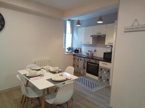 une cuisine et une salle à manger avec une table et des chaises dans l'établissement Coeur de ville cosy, à Morlaix