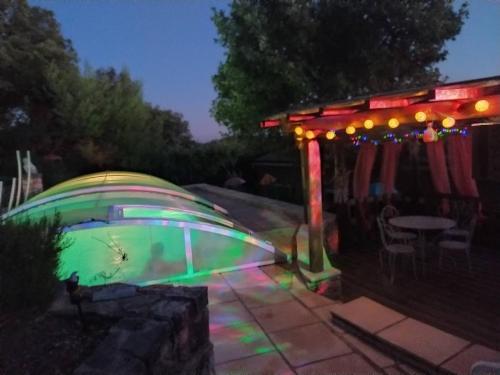 a backyard with a pool with a gazebo and lights at Les Gîtes De Cayenne - Gîte ORIENT in Dions