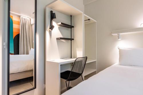 a bedroom with a bed and a desk and a mirror at Graphik Montparnasse in Paris