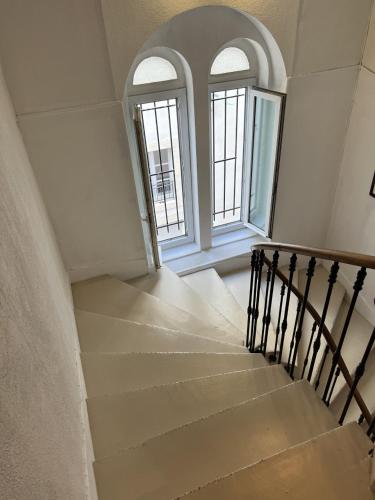 a staircase in a house with two windows at Hôtel Abalone - Centre Gare in Nîmes