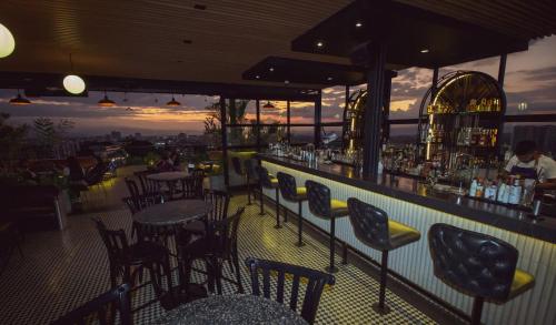 - un bar avec des tables et des chaises noires et un comptoir dans l'établissement Hotel Sexto by Icono, à Armenia