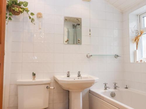 a bathroom with a sink and a toilet and a tub at Bumble Bee Cottage in Faversham