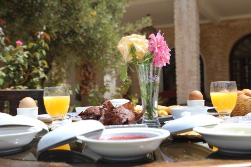 a table with eggs and a vase of flowers on it at Jolies chambres d'hôte au Riad Dharma in Essaouira