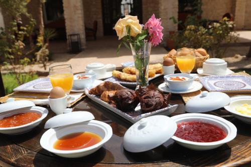 a wooden table with food and drinks on it at Jolies chambres d'hôte au Riad Dharma in Essaouira