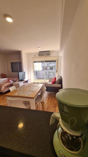 布宜諾斯艾利斯的住宿－Edificio San Juan de Buenos Aires.，厨房以及带吧台上的绿色搅拌器的起居室。