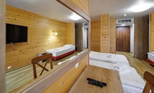 a room with two beds and a flat screen tv at Leśne Patio in Katowice