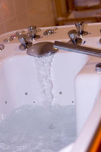 a sink with water coming out of it at Hotel Villa Siesta in Smokovce