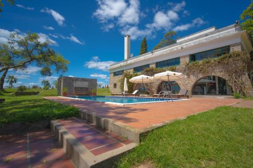 a house with a swimming pool in front of it at Estancia Turística San Pedro de Timote in Reboledo