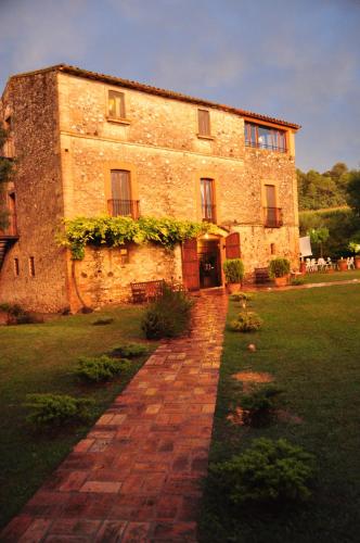 a large brick building with a brick path in front of it at Hotel Masia La Palma in Espinavesa