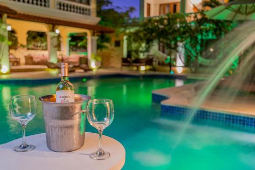 a bottle of wine in a bucket next to a pool at Hotel Villa Beija Flor in Jericoacoara