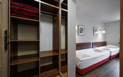 a small room with a bed and a closet at Leśne Patio in Katowice
