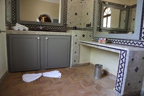 a bathroom with a sink and a mirror at Jolies chambres d'hôte au Riad Dharma in Essaouira