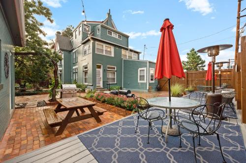 a patio with a table and chairs and a house at Flora House Denver in Denver