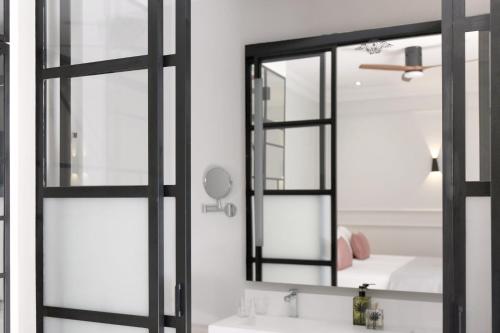 La salle de bains est pourvue d'un miroir et d'un lavabo. dans l'établissement Casa Romana Hotel Boutique, à Séville