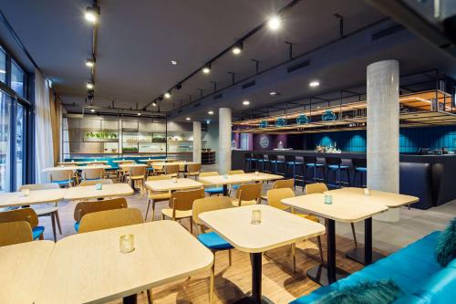 a restaurant with tables and chairs and a bar at elaya hotel goeppingen in Göppingen