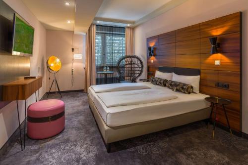 a bedroom with a large bed with a wooden headboard at elaya hotel munich city in Munich
