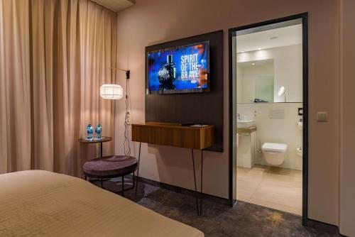 a hotel room with a bed and a bathroom at elaya hotel munich city in Munich