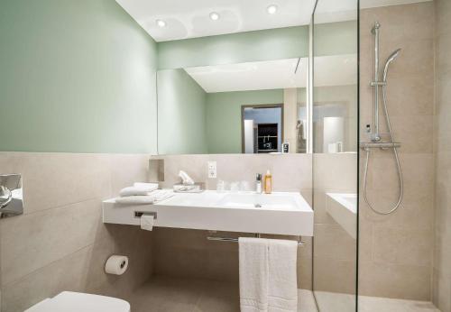 a bathroom with a sink and a shower at elaya hotel oberhausen in Oberhausen