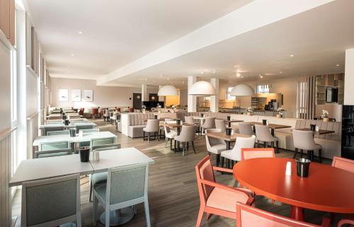 a restaurant with tables and chairs and a cafeteria at Arthotel ANA Amber in Rostock