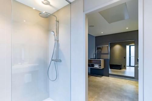 een badkamer met een douche en een glazen deur bij elaya hotel kevelaer in Kevelaer