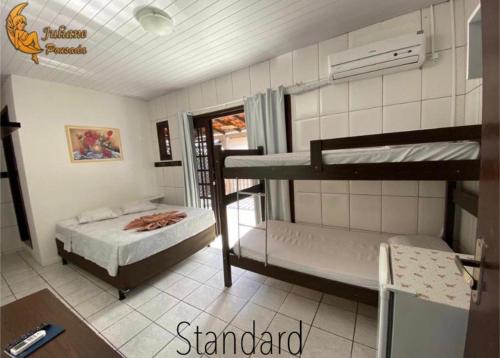 a dorm room with two bunk beds in it at Pousada Juliane in Penha