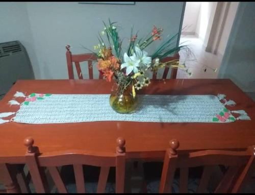 a vase of flowers sitting on a wooden table at Tucuman Centro Departamento in San Miguel de Tucumán
