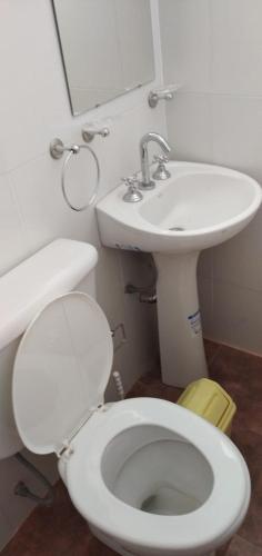 a bathroom with a white toilet and a sink at Sierras Altas Alojamientos in Villa Carlos Paz