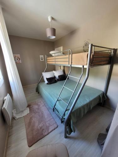 une chambre avec un lit superposé dans une pièce dans l'établissement Maison plein pied sur les hauteurs de Fécamp, à Fécamp