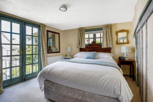 a bedroom with a large bed and large windows at The Tea House in Rye