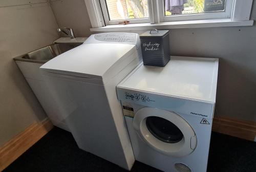 a washer and dryer in a room with a window at Okauia House, Matamata in Matamata