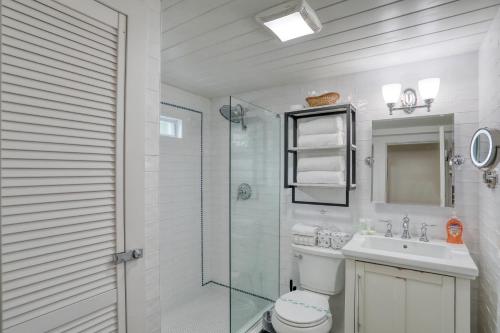 a bathroom with a shower and a toilet and a sink at Bernard Street Bungalow in Saint Augustine