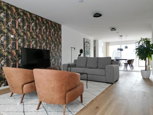 uma sala de estar com um sofá e uma televisão em Traunseeresidenzen em Gmunden
