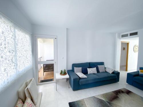 a living room with a blue couch and a window at Bellaluz 18.15, La Manga Club Resort in Atamaría