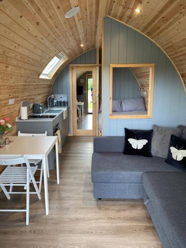 a living room with a couch and a table at Mowbray Cottages & Glamping in South Kilvington