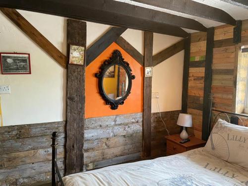 um quarto com uma cama e um espelho na parede em Yarm cottages byre/paddock em Kirk Leavington