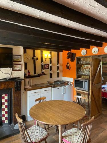 a kitchen with a wooden table and chairs and a table at Yarm cottages byre/paddock in Kirk Leavington