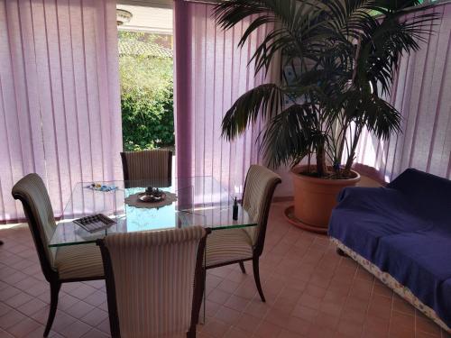a room with a glass table and chairs and a bed at Villa Ermes in Lido Di Fondi