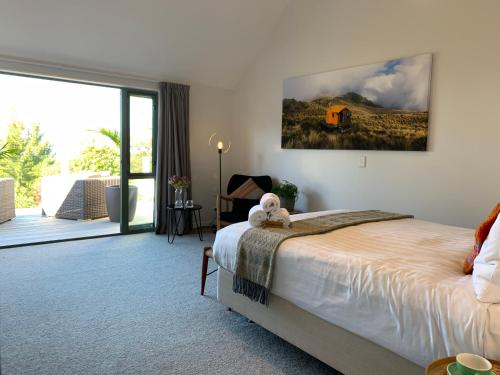 a bedroom with a bed and a sliding glass door at Kaiteriteri Ridge Holiday Estate in Kaiteriteri