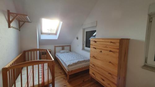 a bedroom with a bed and a dresser and a window at Wiatr i Woda Jastarnia in Jastarnia