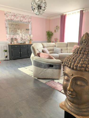 ein Wohnzimmer mit einem Sofa und einer Statue eines Kopfes in der Unterkunft Chambre d'hôtes - La Pinstrie 